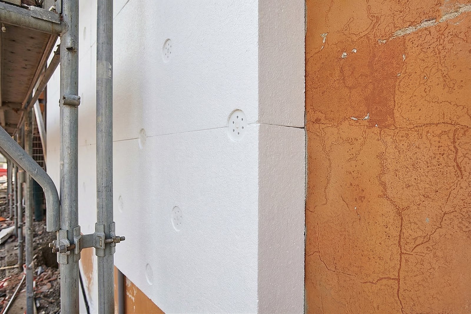 Installation of EPS insulation boards on exterior wall using mechanical anchors in an ETICS system