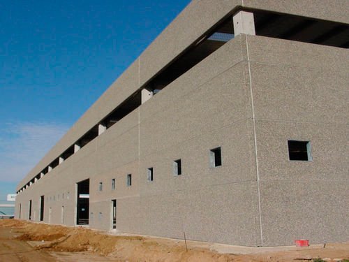 Modern industrial building facade using integrated decorative insulation panels with grey sand-textured finish